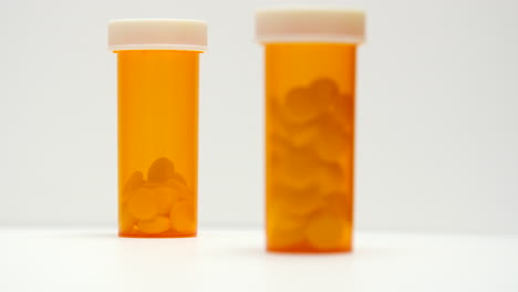 camera pulls focus on pill bottles on white background