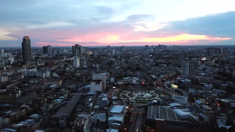 aerial view of city during sunset. flying over huge roundabout in bangkok, thailand