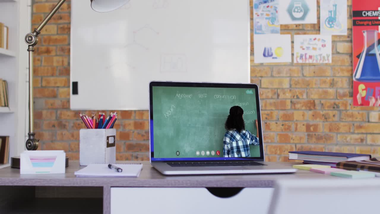 maestra de raza mixta en la pantalla de la computadora portátil durante una videollamada