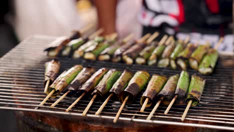 skewers grilling on a street food stall