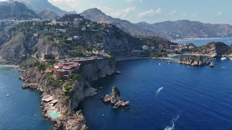 Coastal-cliffs-with-yachts-and-boats-on-a-clear,-sunny-day,-aerial-view