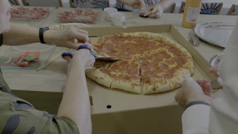 cortando una gran pizza familiar con tijeras