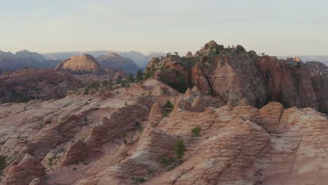slow tracking forward drone over sunset cliffs and green trees within zion national park