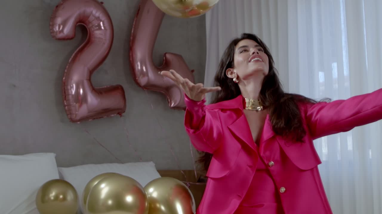 una mujer jugando con globos irradia alegría mientras orbes de colores flotan a su alrededor.