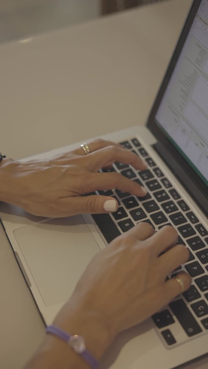 manos femeninas escribiendo en la computadora portátil en el escritorio, vista de cerca