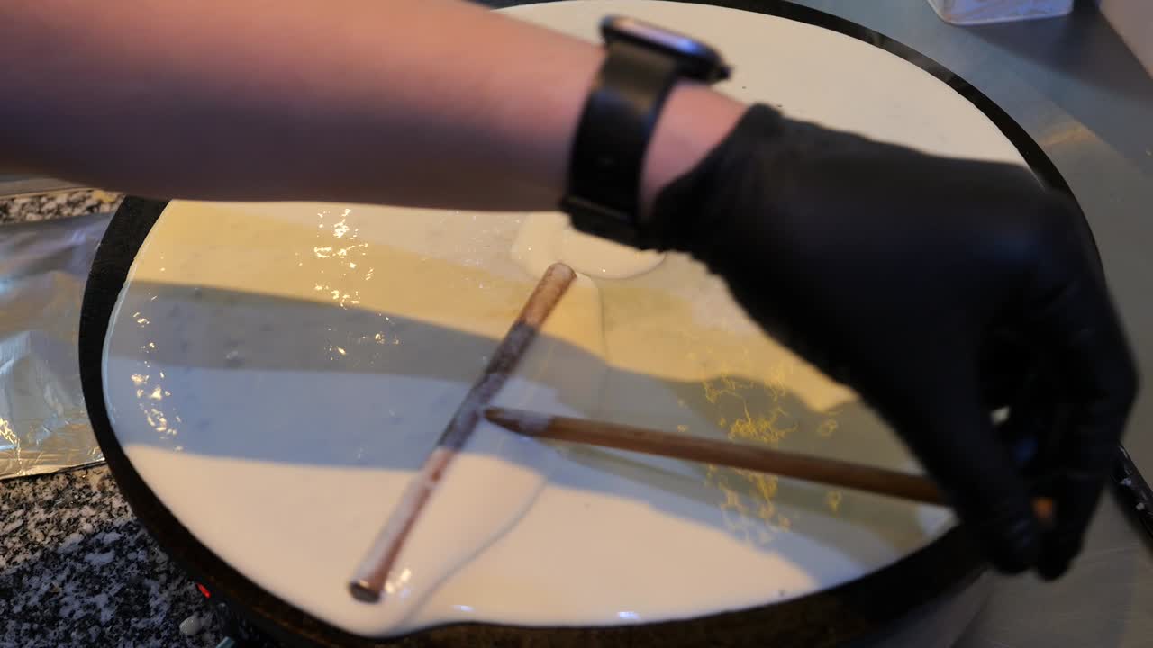 셰프는 팬케이크 반죽을 팬에 습니다.