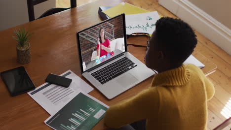 african american woman using laptop on video call with female colleague working from home