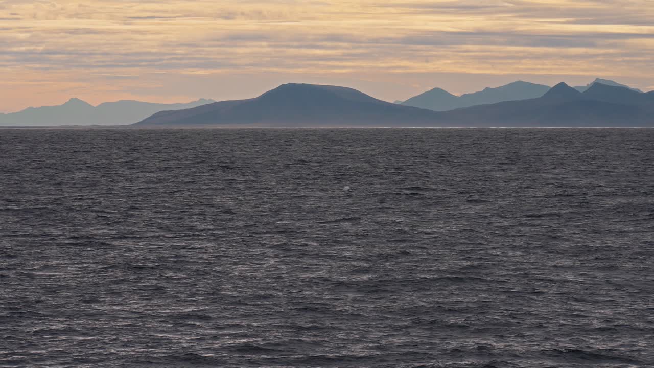 Majestic coastal view of Vestarelen with mountain ranges and ocean waves.