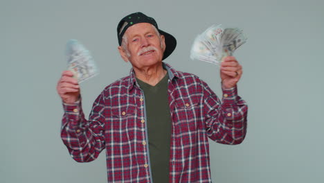 rich pleased boss senior man waving money dollar cash banknotes like a fan, success business career