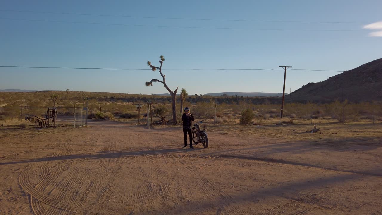 el hombre se prepara para montar una motocicleta retro retro en el desierto