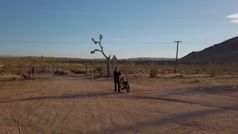 man gets ready to ride vintage retro chopper motorcycle in the desert