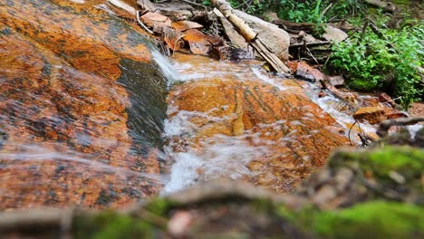 Top-down-view-of-a-small-waterfall-cascading-over-smooth-rocks,-filmed-in-the-Rocky-Mountains-of-Colorado-at-Staunton-State-Park