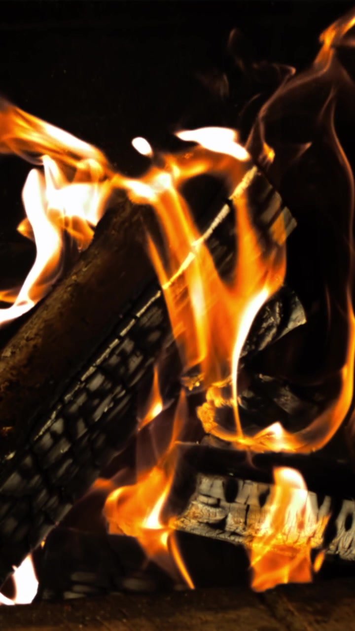 Accogliente camino con ceppi di legno che bruciano e fiamme vivaci.