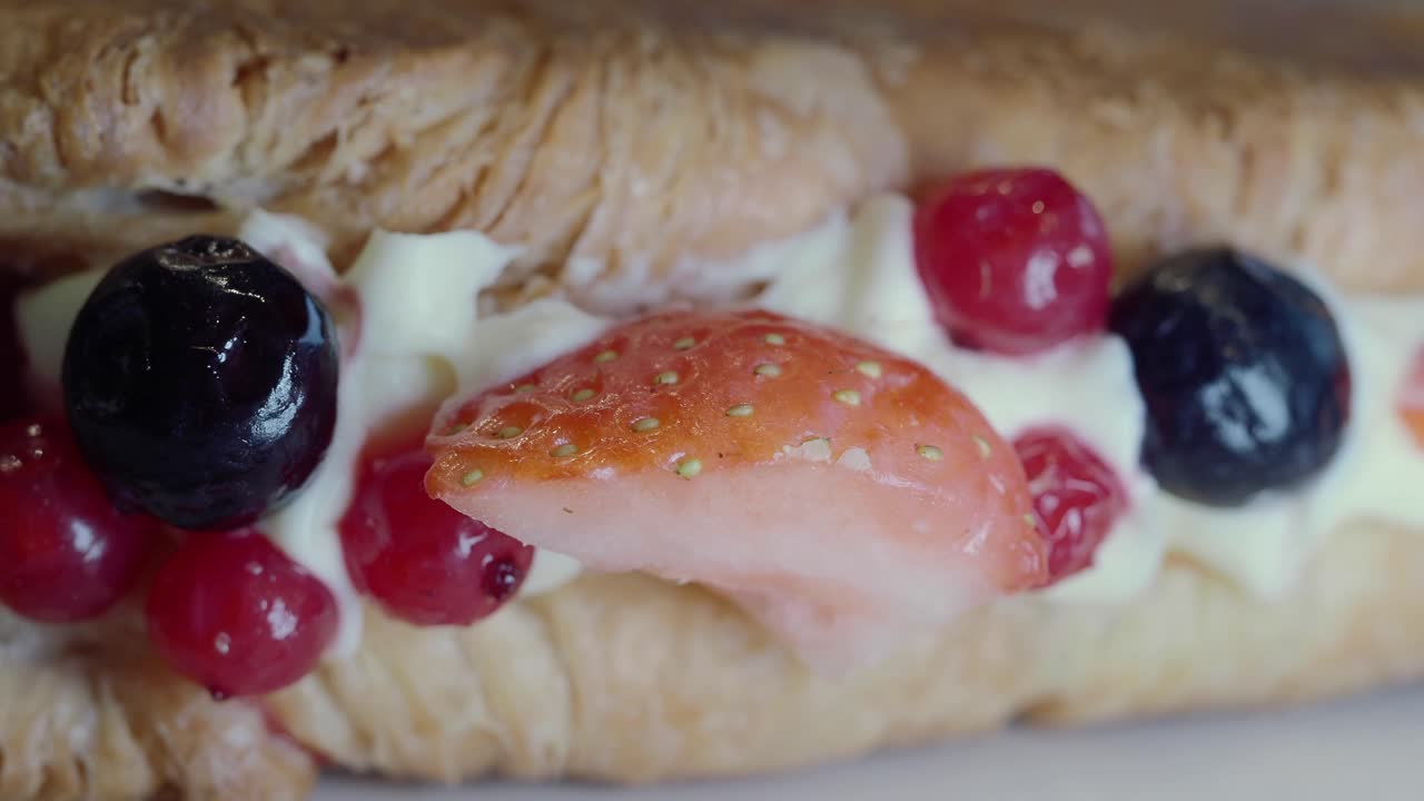 Primo piano di un sandwich dolce di frutta con panna e frutti di bosco