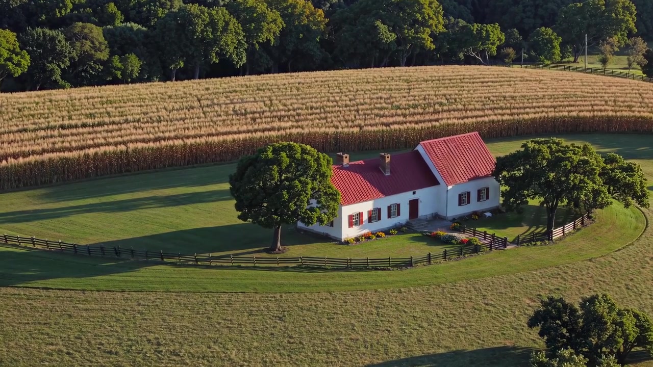 Aerial View of a Charming Farmhouse with Red Roof and Cornfield