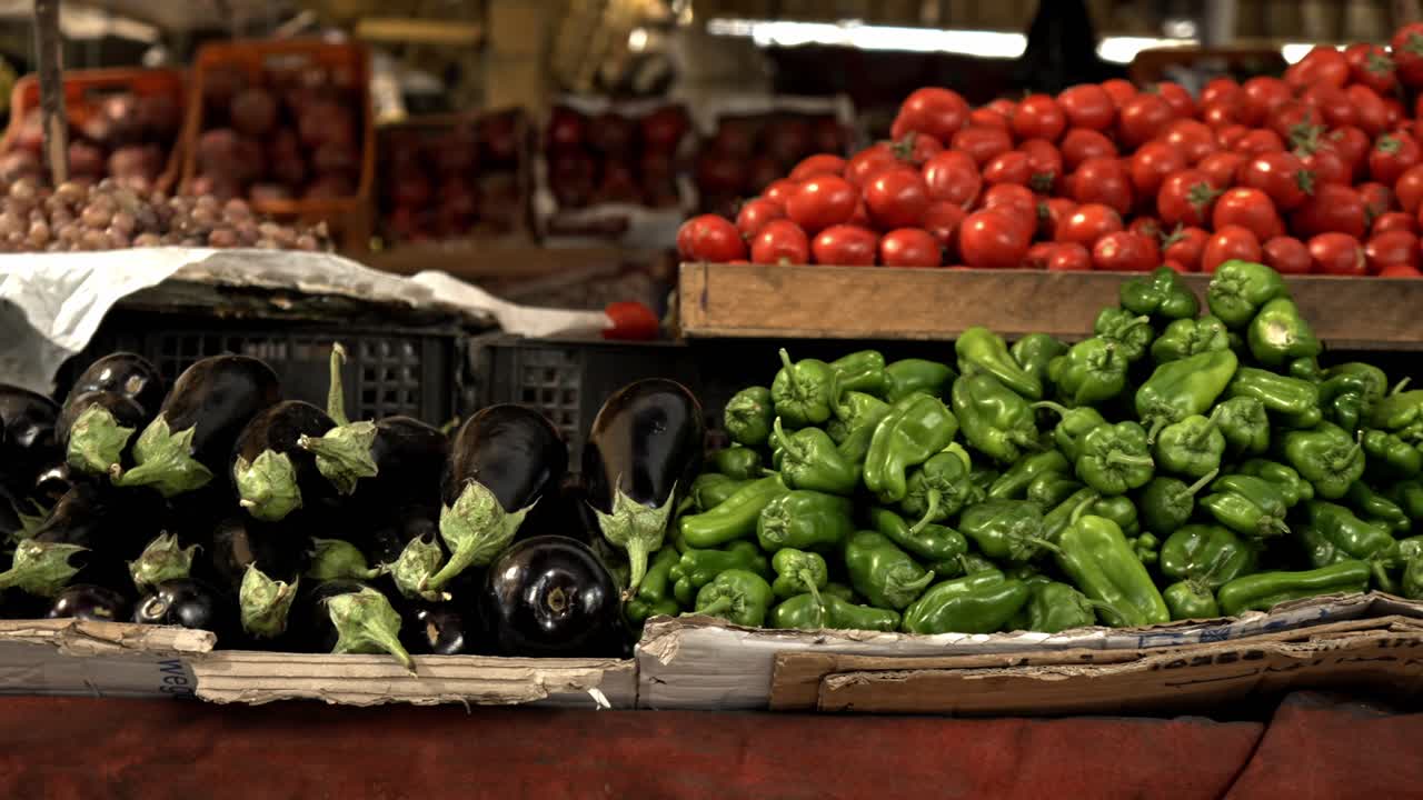 Esta cena destaca a incrível fartura agrícola do Vale do Nilo, apresentando berinjelas roxas escuras, pimentões vibrantes e montes de tomates maduros.