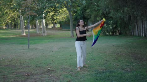 mujer con bandera de orgullo en un parque