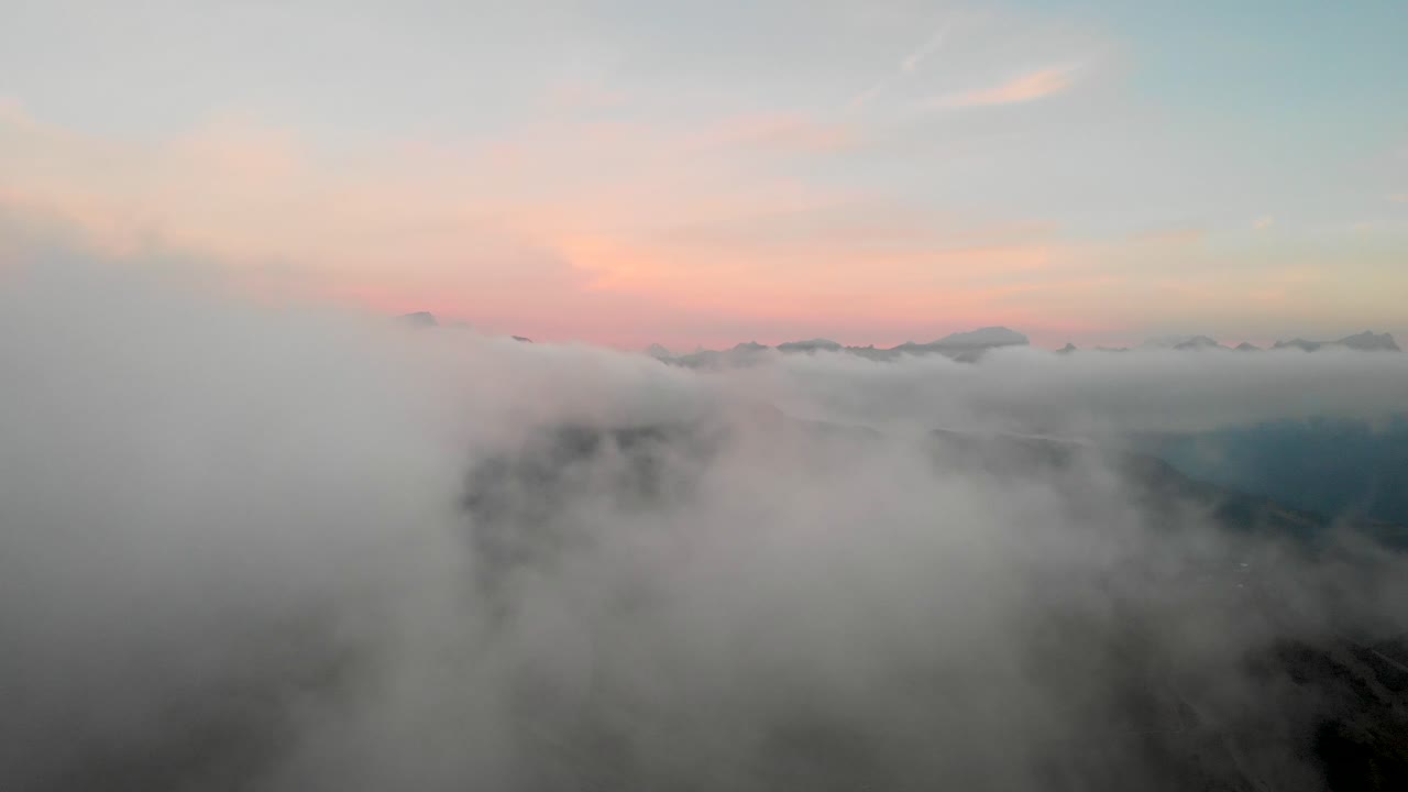 스위스 알프스 산맥에서 다채로운 가을 해가 지는 동안 다양한 산꼭대기가 보이거나 보이지 않는 스위스 바우드의 레이신의 구름 위의 공중 비행