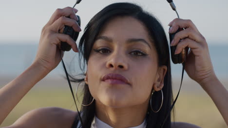 retrato mujer hispana atractiva se pone auriculares escuchando música disfrutando del cálido verano al aire libre en cámara lenta