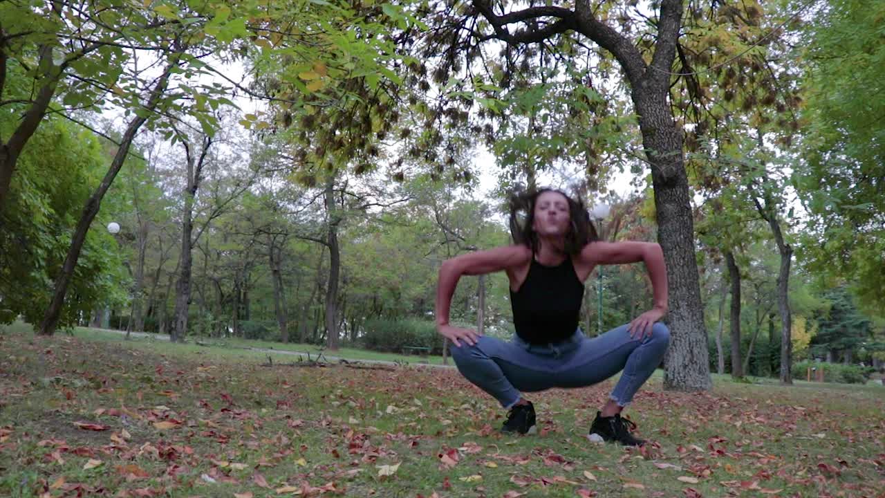 bailarina baila saltando y pateando sus piernas en el aire en un parque
