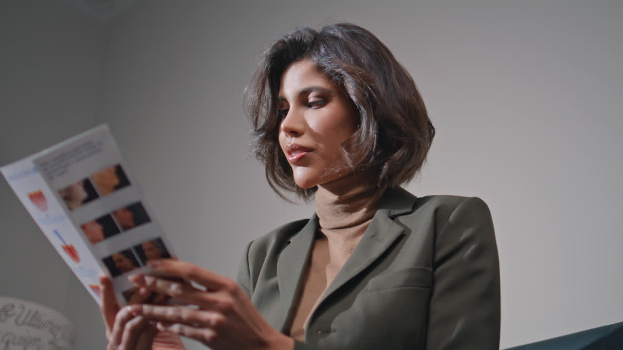 Young woman reading brochure in beauty clinic closeup. businesswoman