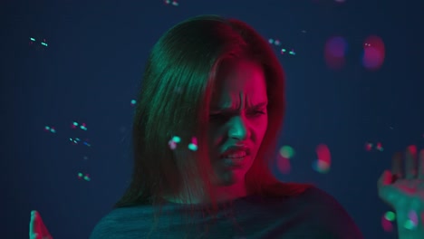 Woman with a displeased expression in neon lights