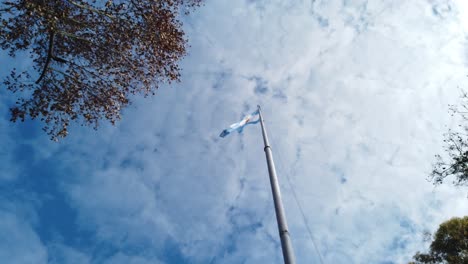argentinian flag waving against a cloudy blue sky