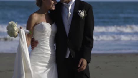 Sonriente-Pareja-De-Recién-Casados-Caminando-Por-La-Playa