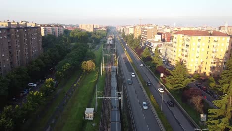 Metro-De-Pasajeros-Que-Viaja-A-Través-Del-Distrito-Vivo-De-Milán,-Vista-Aérea