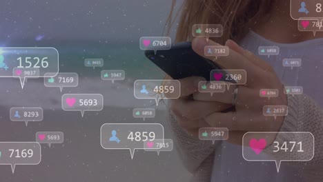 animación de iconos de redes sociales con números sobre mujer caucásica usando teléfono inteligente.