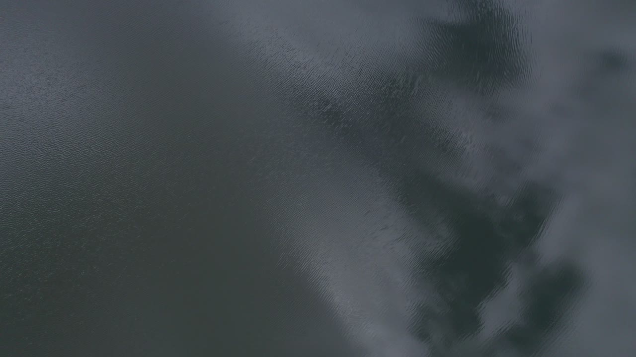 호주 북부 퀸즐랜드의 물에 흐린 하늘이 반사된 모리스 호수의 조감도 - 드론 샷