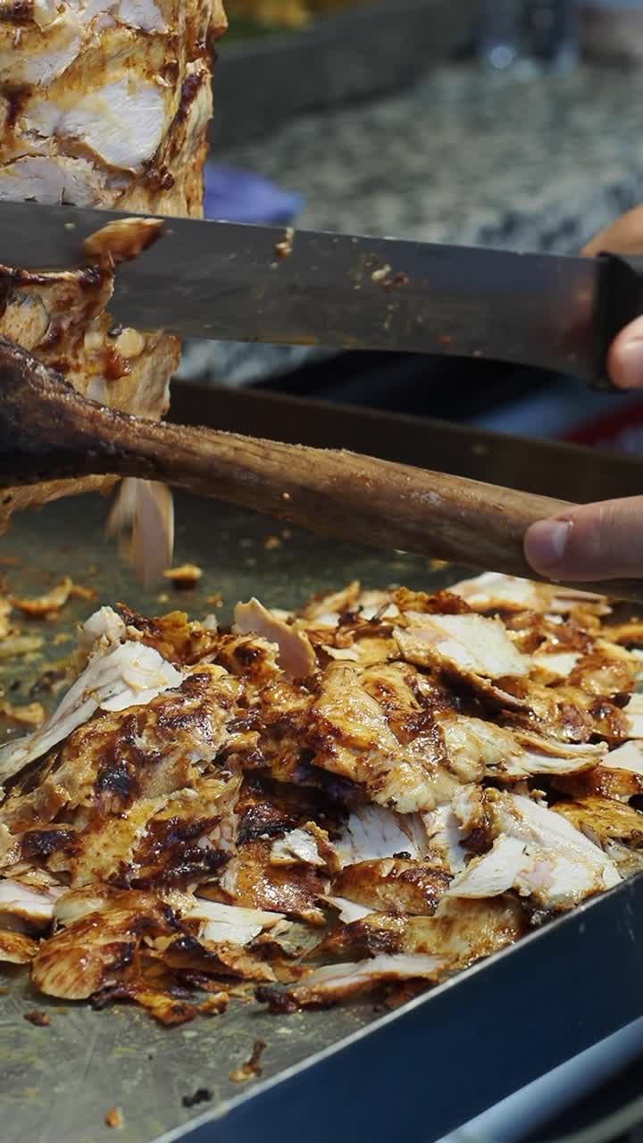 Chef che affetta carne di döner kebab cotta dallo spiedo verticale
