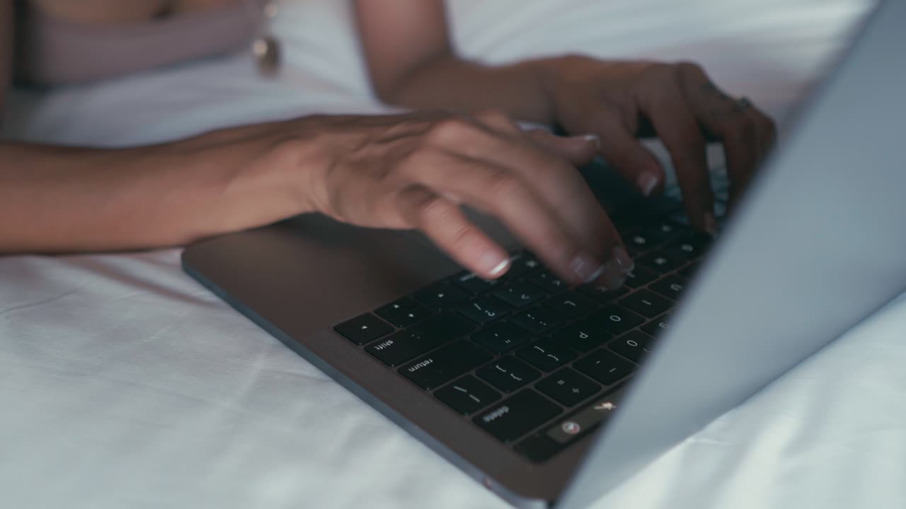 mujer trabajando en la computadora portátil en la cama