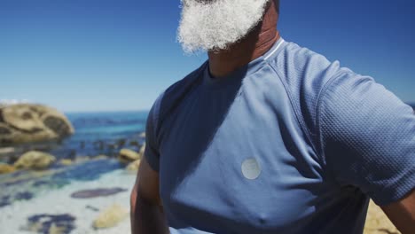 Hombre-Afroamericano-De-Alto-Rango-Tomando-Un-Descanso-Durante-El-Ejercicio,-Admirando-Las-Vistas-Al-Mar