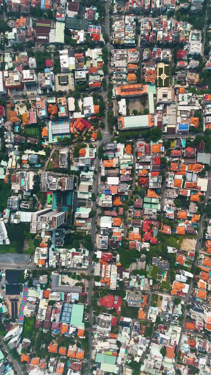 Vertical top-down aerial view of a residential area in Ho Chi Minh City (Saigon), Vietnam, with street traffic. Captures the urban landscape and daily life.