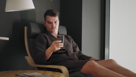 man is using modern smartphone viewing social media in internet relaxing in spa center