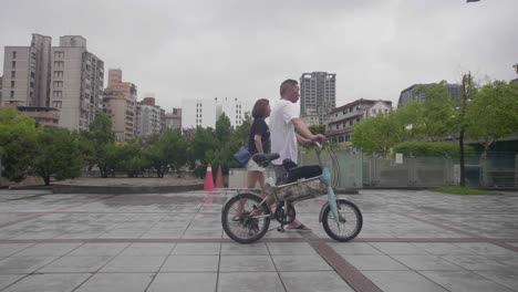 hombre y mujer caminando con bicicleta taipei