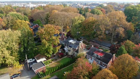 Scenic-vintage-houses-in-fancy-neighborhood-with-tree-alleys-in-autumn-colors,-aerial-view-of-urban-area-in-Pennsylvania