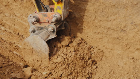 Powerful-Excavator-Bucket-Extracts-Ground-From-The-Pit-Laying-Communication-At-The-Construction-Site