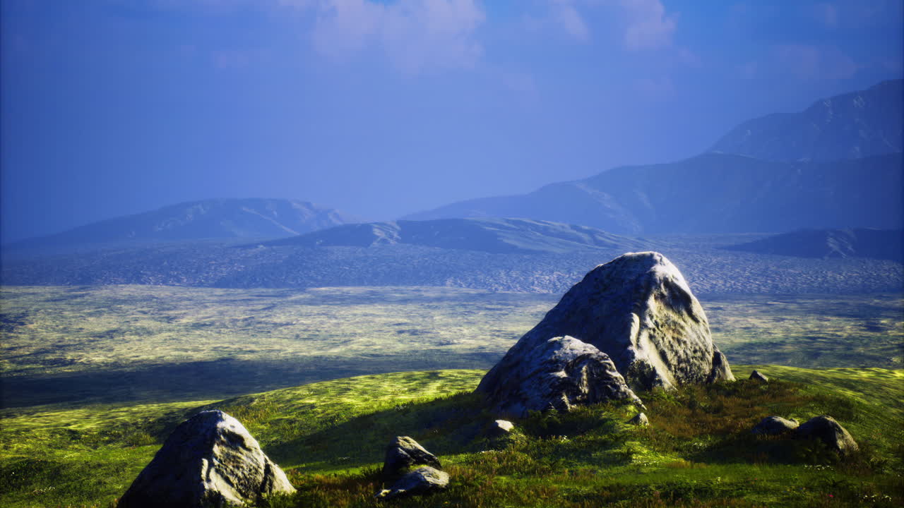 Scenic view of expansive landscape with rocks under a blue sky