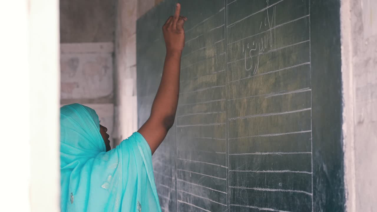 이슬람 학교에서 수업을 가르치는 히잡을 쓴 아프리카 이슬람 교사