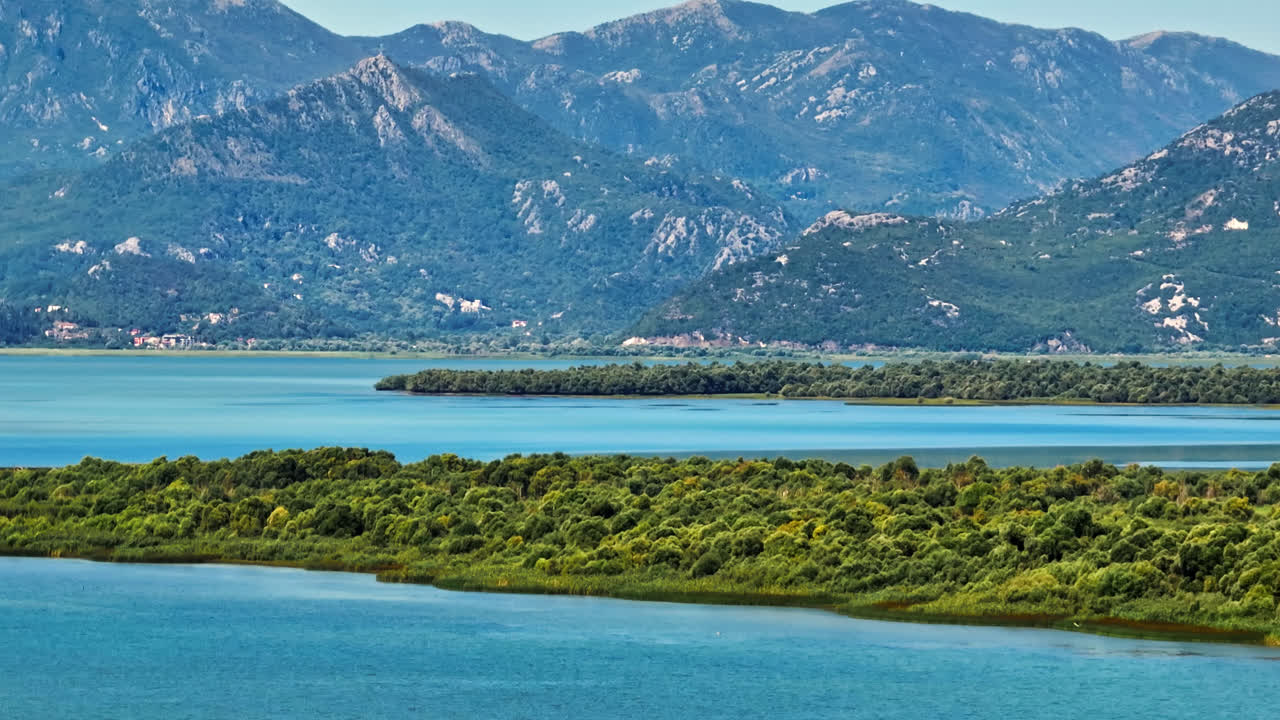 воздушный вращающийся снимок зеленой растительности и гор на озере скадар, черногория