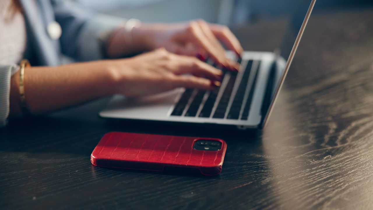Donna che lavora al computer portatile e usa il cellulare