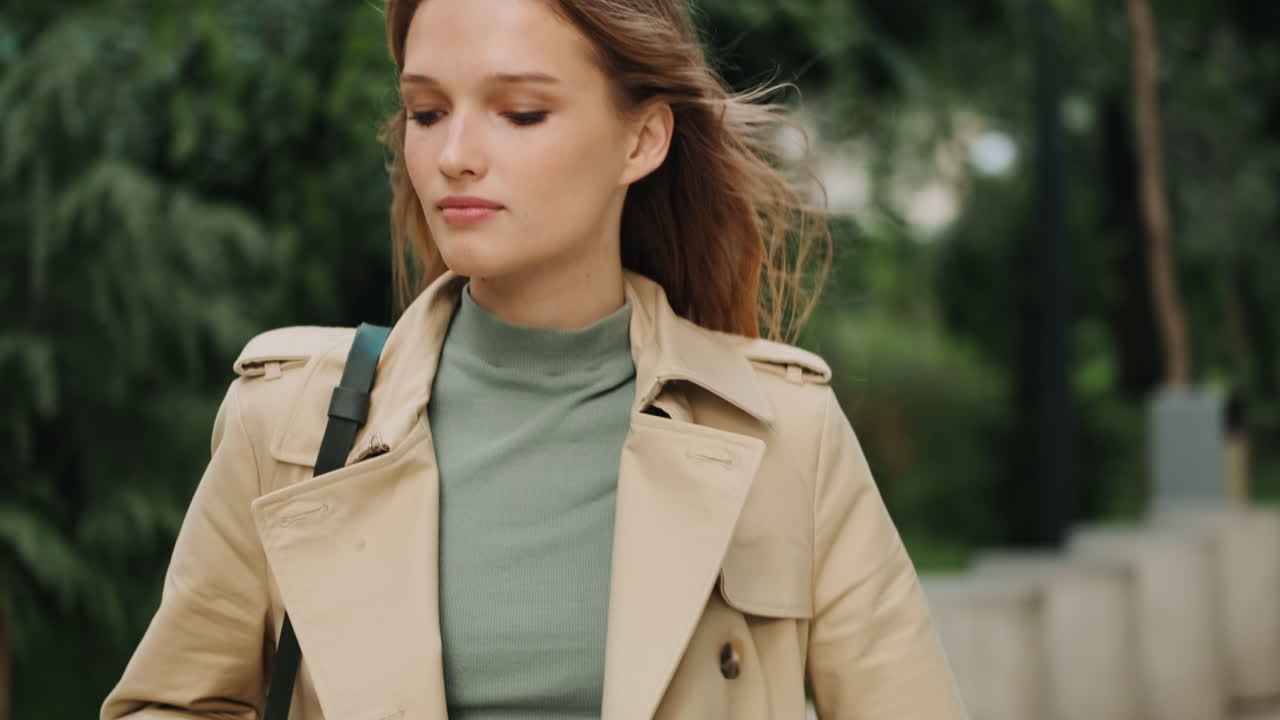 una estudiante caucásica caminando al aire libre.