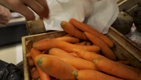 Woman-picks-carrot-in-market