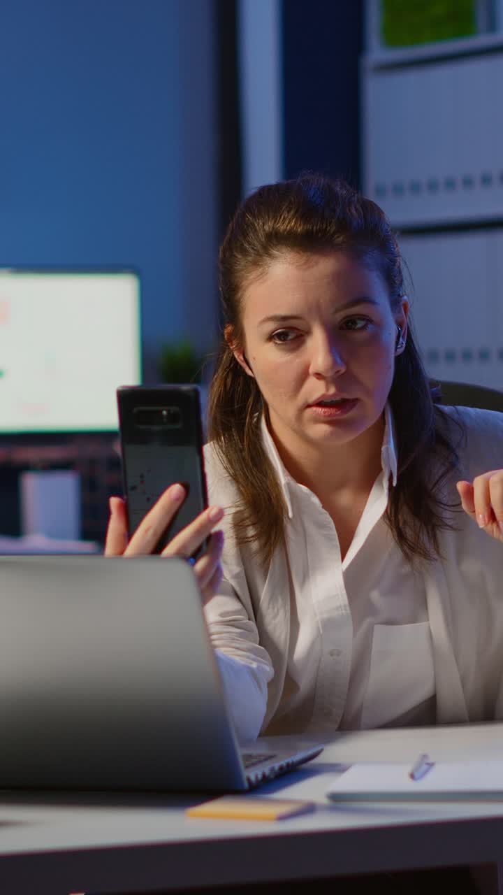 Vertical video: Business woman discussing during video conference with partners using smartphone