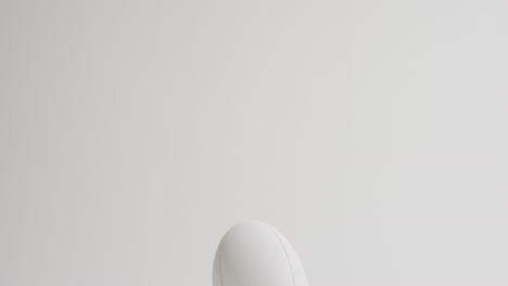 pelota de rugby blanca en patear tee en fondo blanco con espacio de copia, cámara lenta