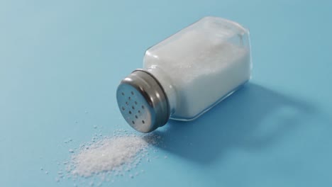 Video-of-salt-in-a-salt-shaker-on-blue-background