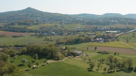 drone - aerial panorama fly over shot of a meadow with grass and bushes and the siebengebirge - seven mountains in the background 30p