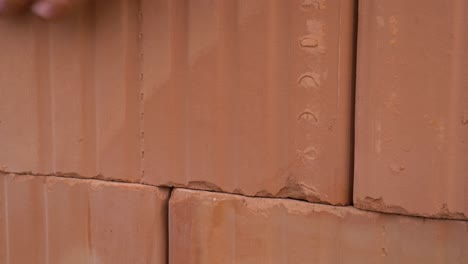 closeup of ceramic block lowered on building foam during house construction